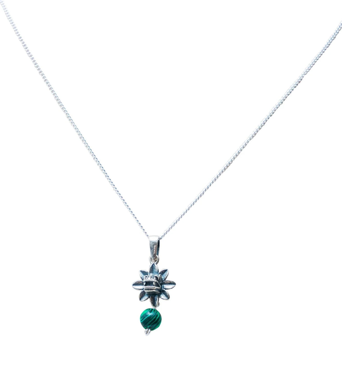 A silver chain necklace featuring a small silver flower charm with a clear crystal center and a dangling green bead below, shown against a plain white background.