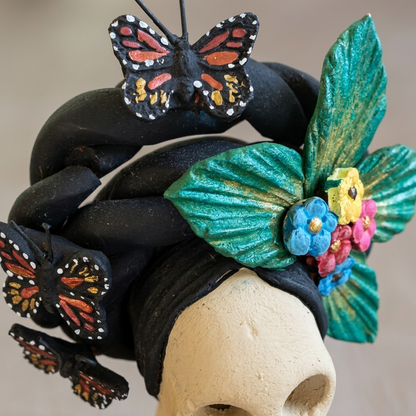 Close-up of colorful handmade Mexican clay Catrina head with detailed butterfly and floral decorations