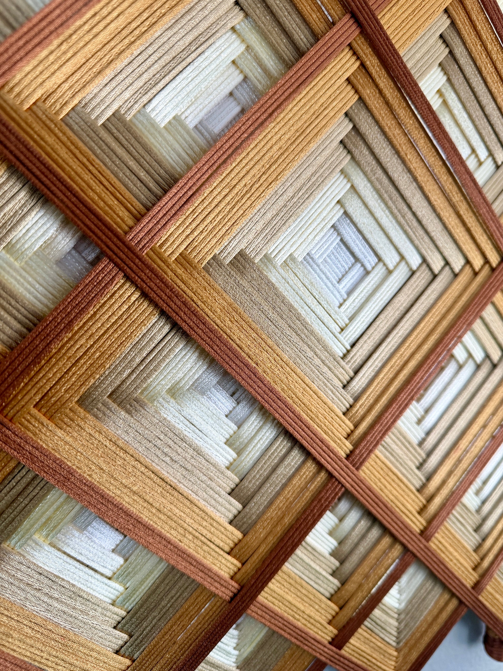 Authentic Oaxacan sacred geometry wall art featuring a handcrafted woven mandala in gold, cream, and brown tones for modern home décor.