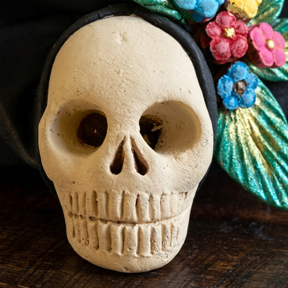 Close-up of colorful handmade Mexican clay Catrina head with detailed butterfly and floral decorations
