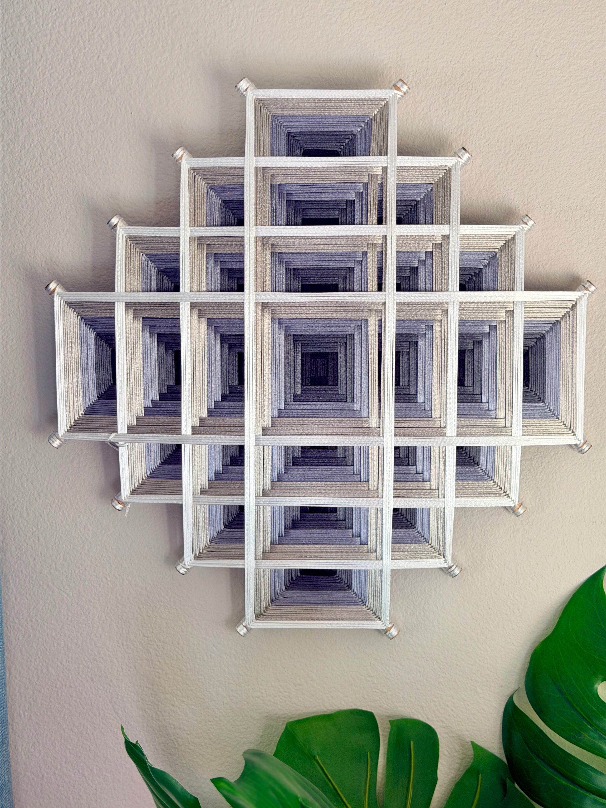 Contemporary Oaxacan fiber art mandala featuring layered geometric patterns in silver, gray, and white for meditation and living spaces